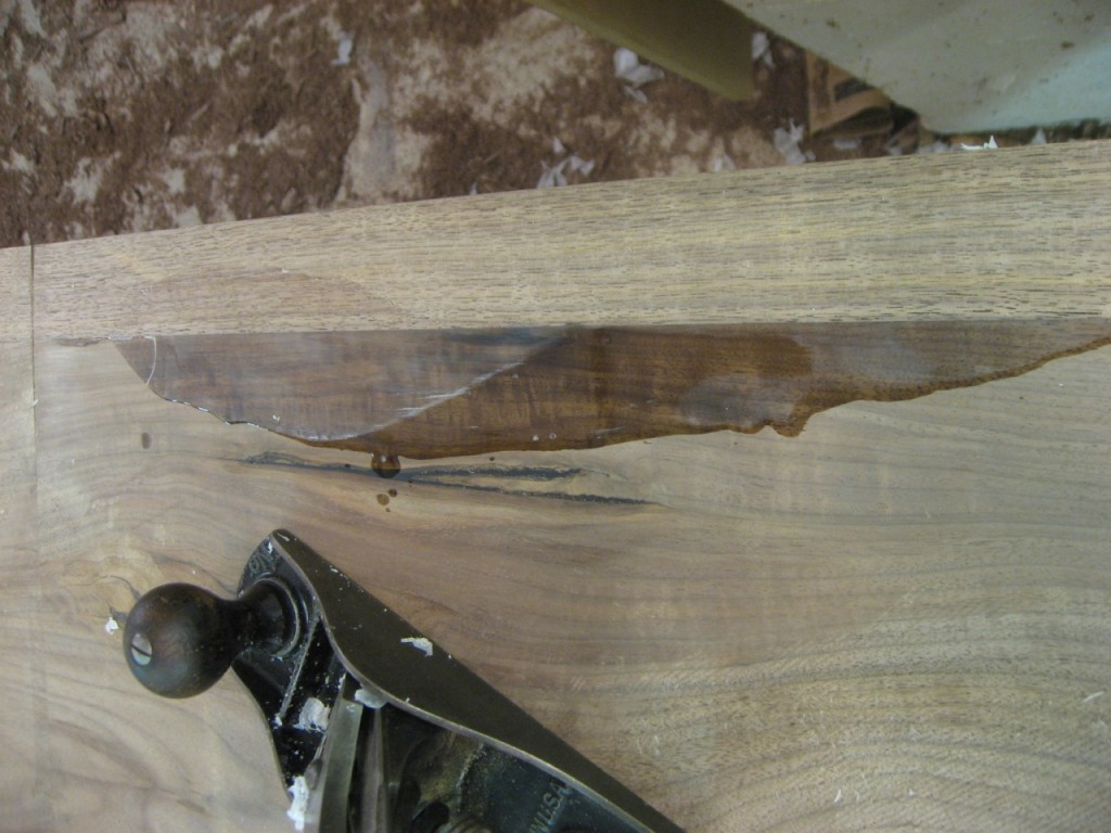 The epoxy is leveled with a hand plane, to be sanded later.