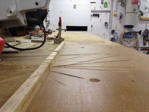 The bottom lines up with the top of the saw table.