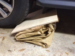 In our case, the garage floor is smooth enough that we didn’t need a piece of plywood on the bottom. If I’d been doing this in the street, on asphalt, I would have used one to protect the tarp plastic from puncture damage.