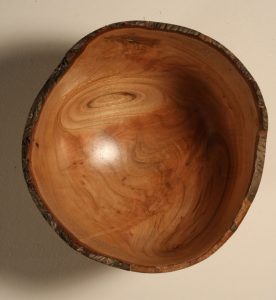 This shows the interior of the natural edge cherry bowl showing the interesting grain patterns caused by two of the larger knots.